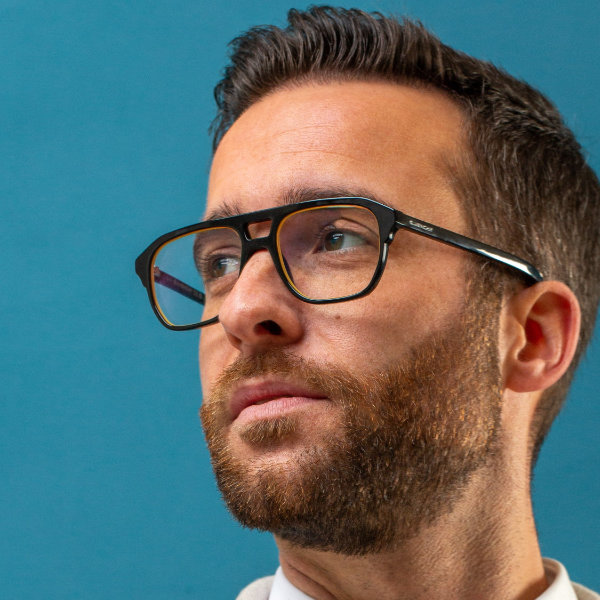 Nahaufnahme einer Brille mit Brillenglas-Randbeschichtung in einer ähnlichen Farbe wie die Brille selbst.