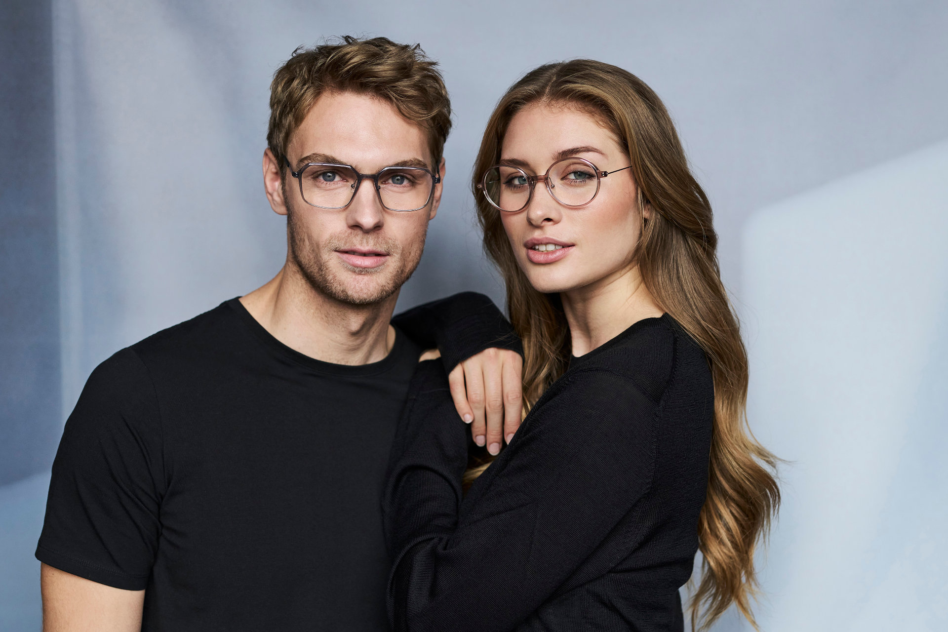 Eine Frau leng ihre Hände aufdie Schulter eines Mannes. beide tragen Brille von nine eyewear.